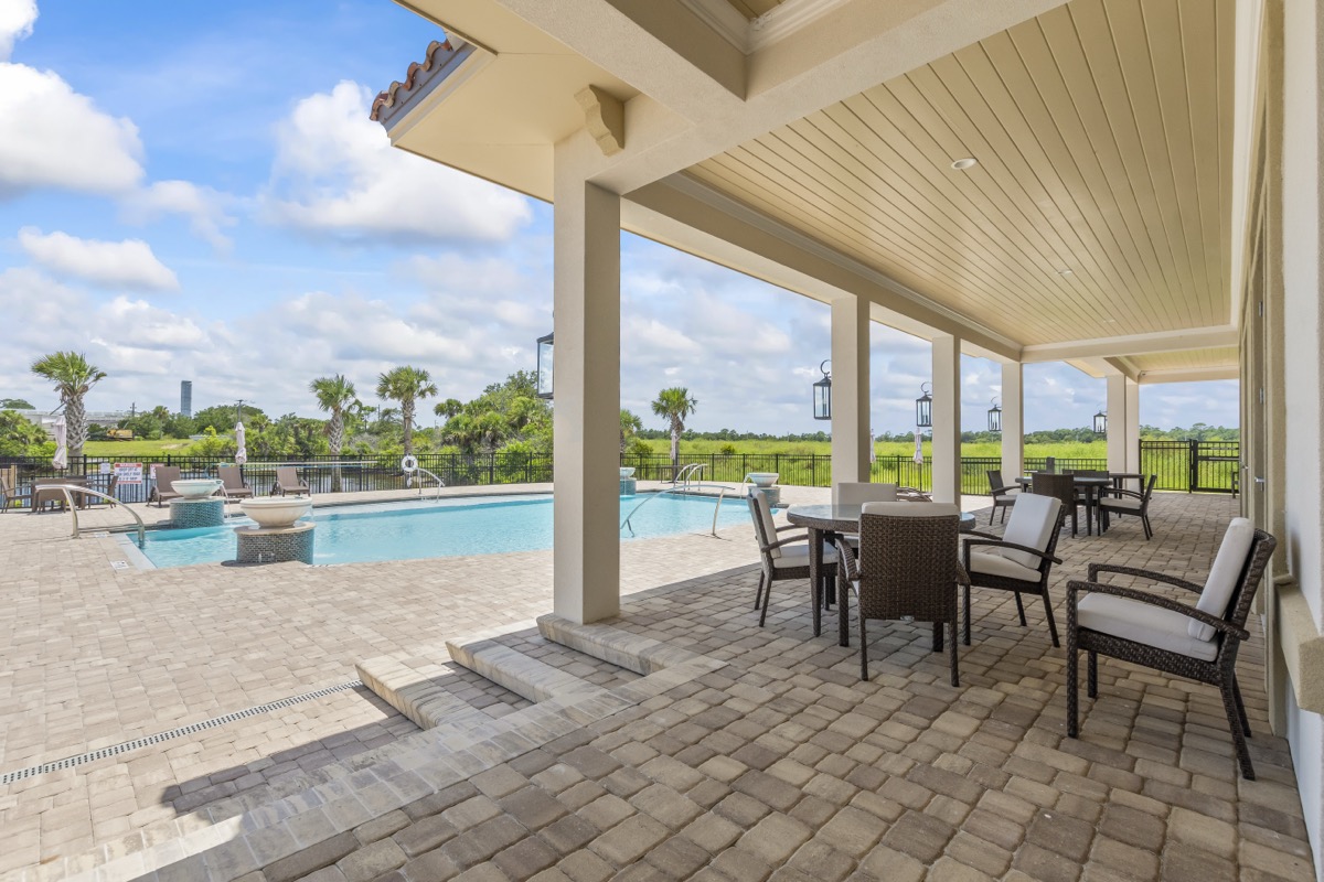 Covered waterfront lanai with seating overlooking the pool at Marina Del Palma
